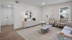 A modern living room with a sofa, armchairs, a coffee table, and a sideboard.