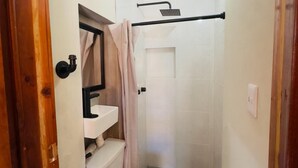 Une petite salle de bain comprenant des toilettes, un lavabo et une douche.
