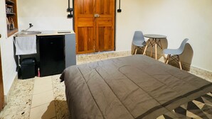 Une chambre à coucher avec un lit, un bureau, une chaise et une petite table.