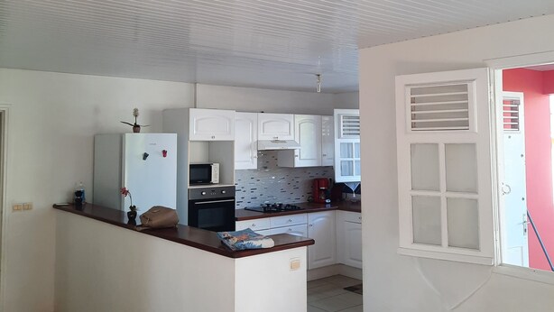 Una cocina moderna con armarios blancos, una isla central y un microondas.