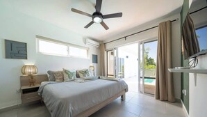 A bedroom with a bed, ceiling fan, and a view of the outdoors. - Ocean View • Style • Freedom (Casa Linda)
