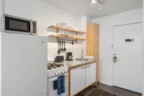 Estúdio standard, 1 cama Queen, cozinha, vista para o pátio | Cozinha privada | Geladeira grande, micro-ondas, fogão, cooktop