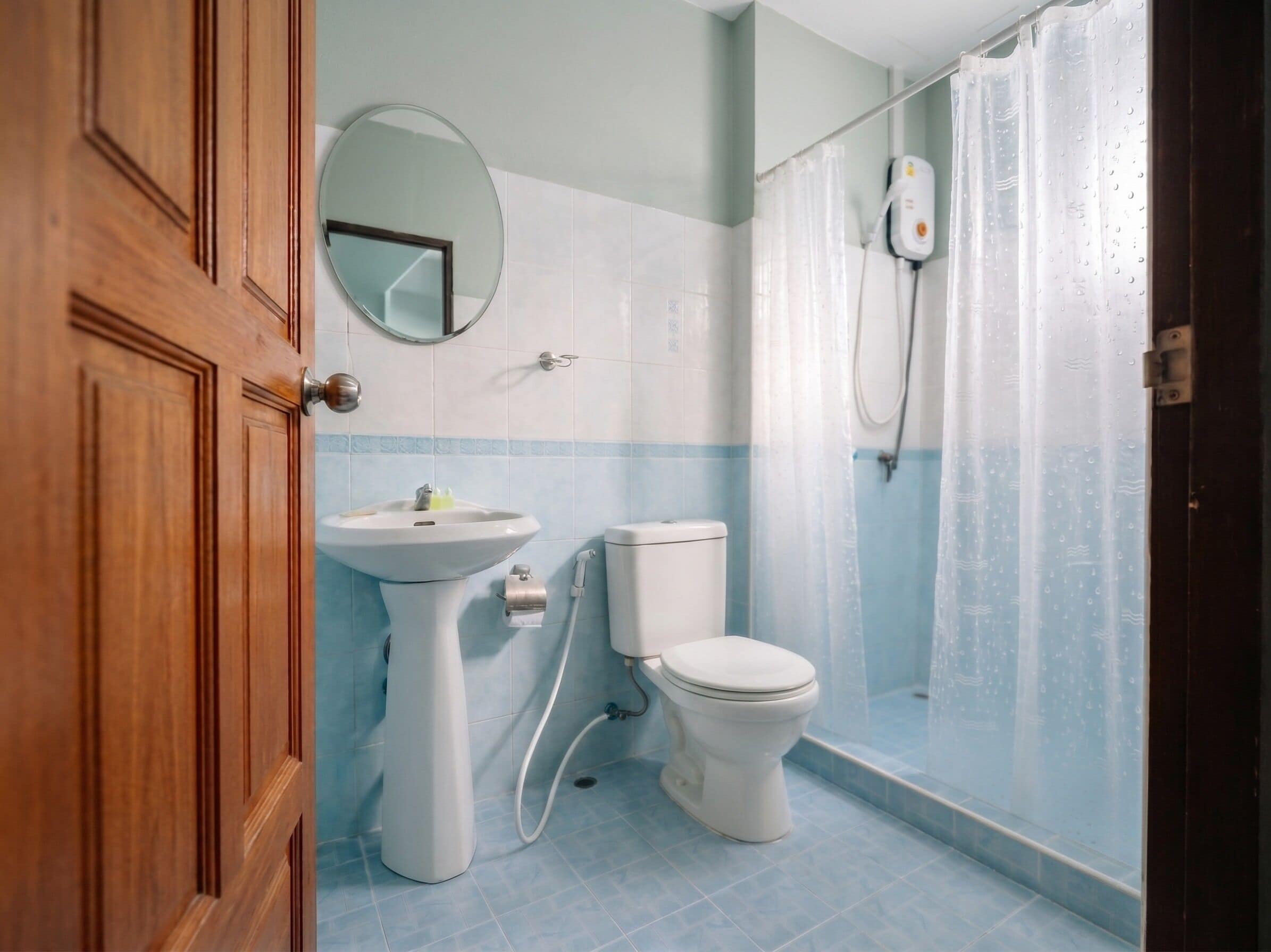 A bathroom with a sink, toilet, and shower curtain.