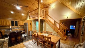 A spacious kitchen with wooden cabinets and a dining area with a wooden table and chairs.