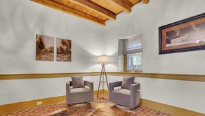 A room with two armchairs, a floor lamp, and a framed picture on the wall. - Cottage at High Cross Farms | Front Porch (Mount Joy)