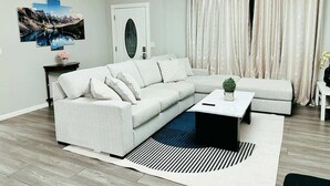 A modern living room with a light grey sectional sofa, a black coffee table, and a patterned rug. - Beauty Home 3Br/2Bath Nearby Downtown in San Jose (San Jose)