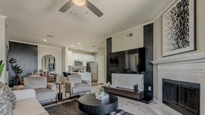 A modern living room with a fireplace, a dining area, and a kitchen in the background. - Scottsdale 2BR • Pool • Gym •Free Parking •Central (Scottsdale)