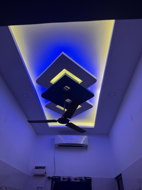 A room with a ceiling fan, recessed lighting, and an air conditioning unit. - SK RESIDENCY NAGORE (Nagapattinam)