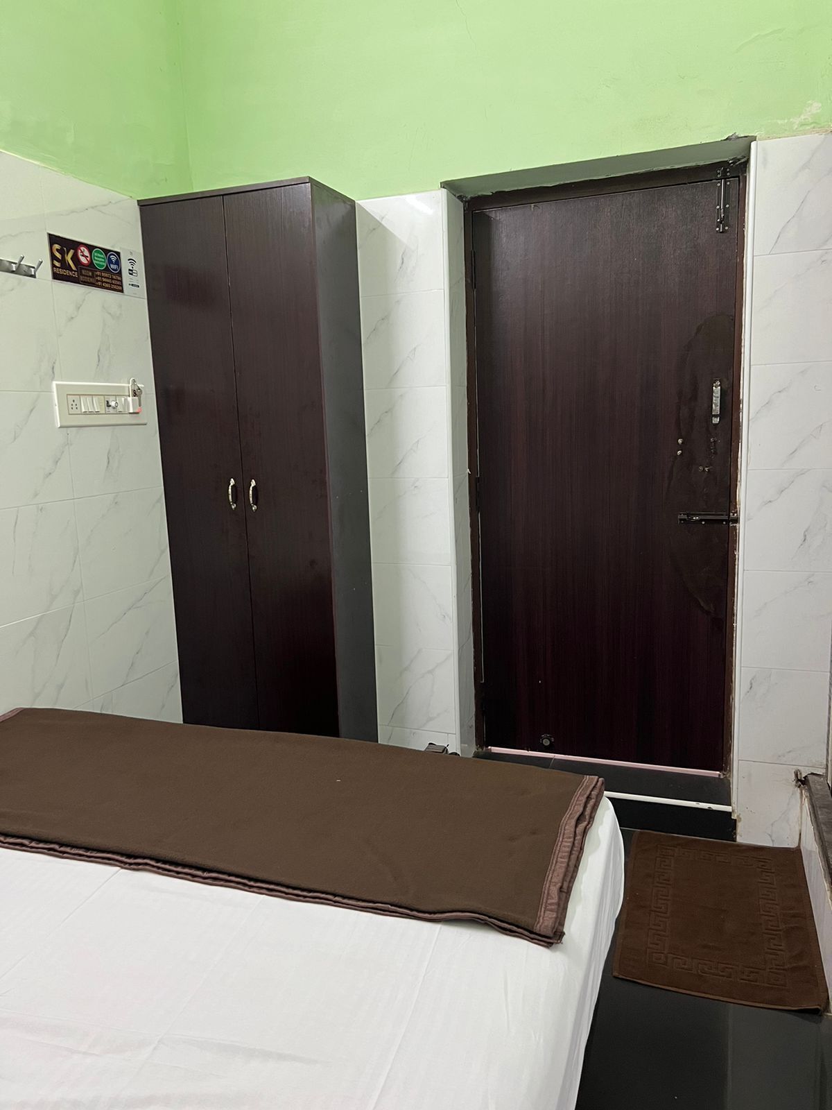 Un dormitorio con cama, armario y puerta.