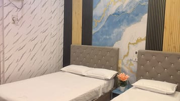 A hotel room with two beds, a marble wall mural, a ceiling fan, and an air conditioning unit.