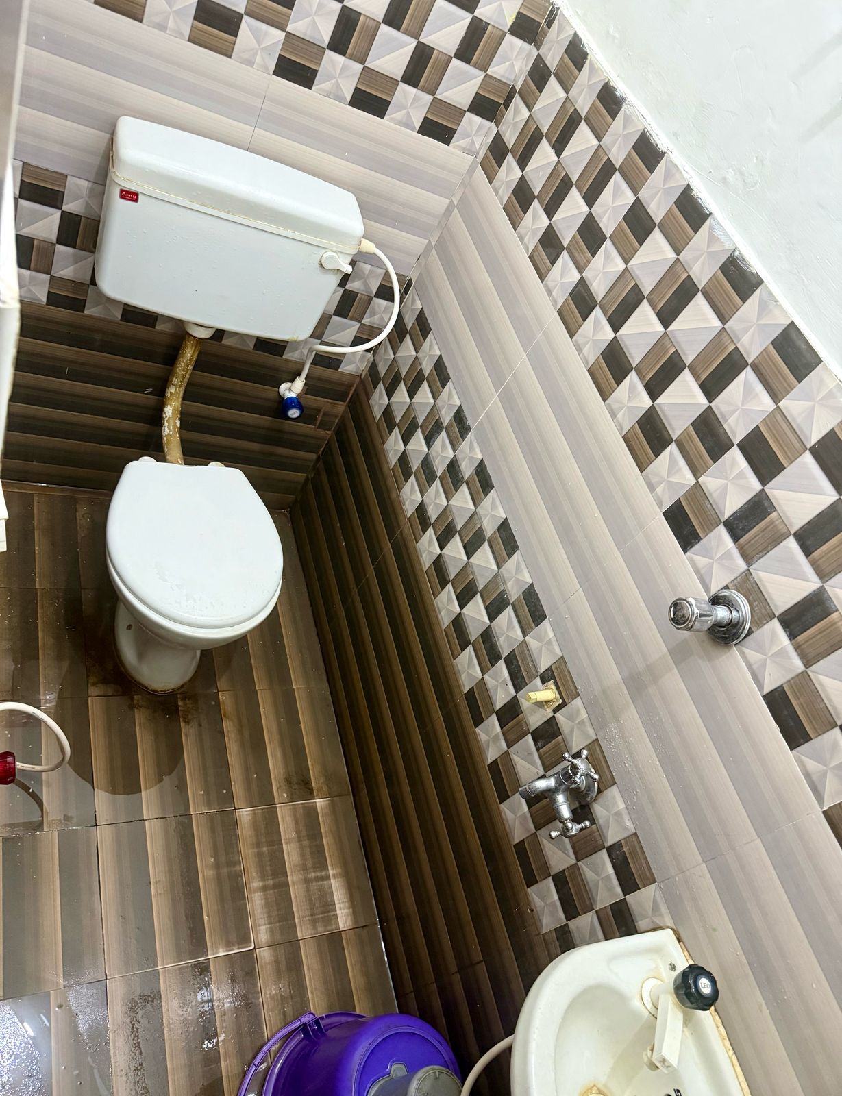 Un baño con inodoro, lavamanos y paredes con azulejos.
