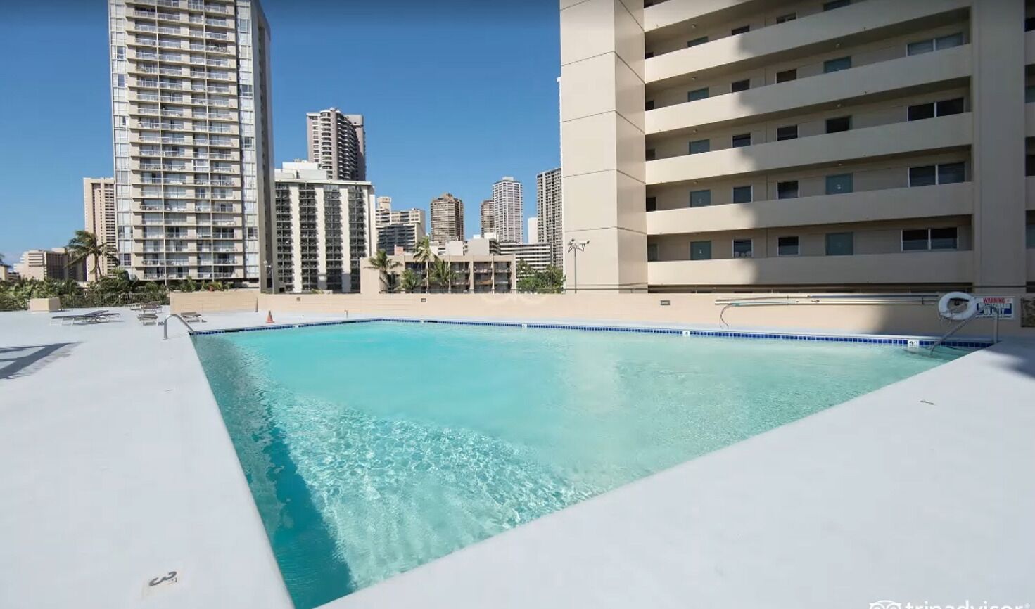 Una piscina en la azotea con el horizonte de la ciudad al fondo.