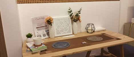 A wooden desk with a white sign, decorative vases, and a framed picture.