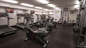 Et fitnesscenter med løbebånd, crosstrainere og styrkemaskiner.