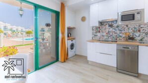 Una cocina moderna equipada con microondas, horno y lavadora.