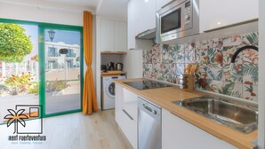 Cocina moderna con microondas, lavamanos y encimera de madera.