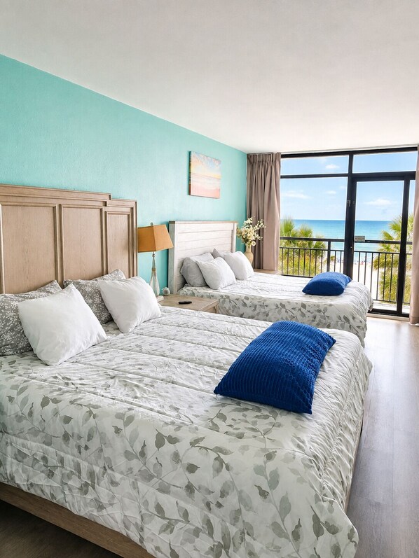 A hotel room with two beds, a view of the beach, and a balcony. - Direct oceanfront studio in Landmark Resort with fabulous water amenities (Myrtle Beach)