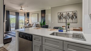 Eine moderne Küche mit Geschirrspüler, Spüle und einem Essbereich mit Tisch und Stühlen.