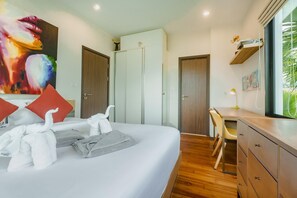 Ein Hotelzimmer mit Bett, Schreibtisch, Stuhl, Kleiderschrank und einem großen Fenster mit Blick auf Grünflächen.