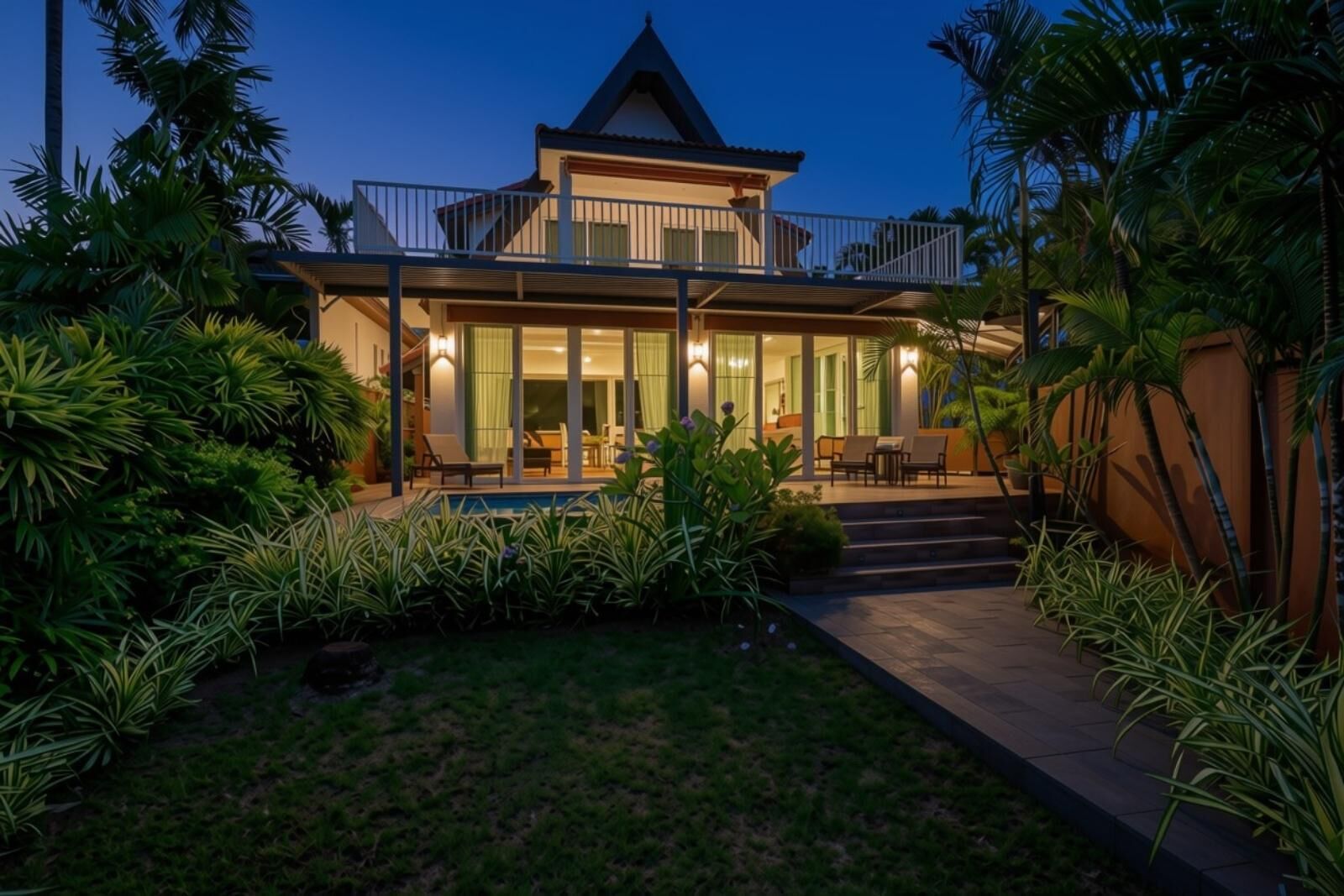 A modern house with a swimming pool, surrounded by tropical plants.