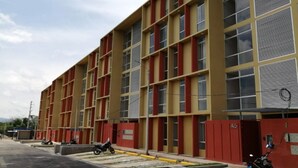 Un edificio de varios pisos con una fachada roja y amarilla y una cuadrícula de ventanas.