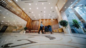 A spacious lobby with a marble floor, a luggage cart, and a staircase. - NHA KHACH TONG LIEN DOAN (Ho Chi Minh City)