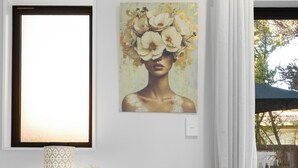 A modern room with a wooden desk, a framed artwork, a vase with flowers, and a view of the outdoors. - Apartment on Short (Christchurch)