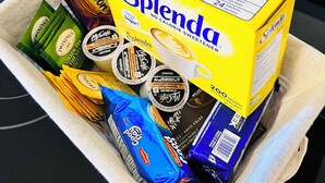 Una caja de sobres de Splenda edulcorante y varias bolsitas de té, incluyendo Twinings y McEve's, sobre una encimera de cocina.