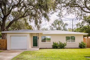 A single-story house with a garage, a front door, and a small front yard.