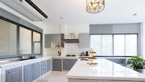 Una cocina moderna con gabinetes grises, una isla grande y un horno empotrado.