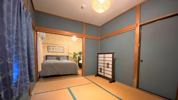 A traditional Japanese-style bedroom with tatami flooring, a bed with a headboard, a shoji screen, and a ceiling light fixture. - TraditionalJapanese Vacation house near to metro station, 4 bedroom Multiple bath (墨田区)