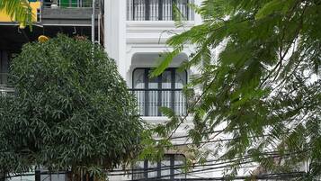 Un hôtel à la façade traditionnelle, doté d’un balcon avec une balustrade et d’un drapeau.