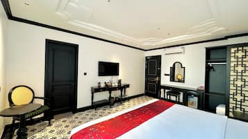 Une chambre d’hôtel comprenant un lit, un bureau, une chaise, une télévision et un miroir.