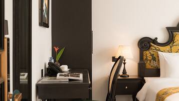 Una habitación de hotel con escritorio, silla, cama y espejo.