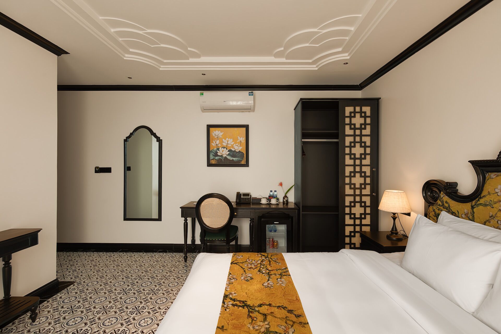 Une chambre d’hôtel comprenant un lit, un bureau, une chaise, une armoire et un miroir.