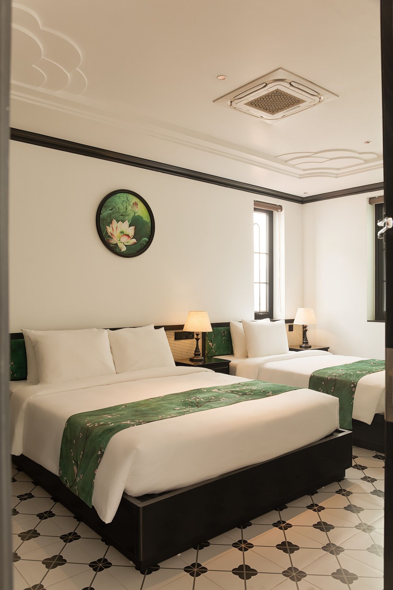 Una habitación de hotel con dos camas, un ventanal grande y un adorno en la pared.