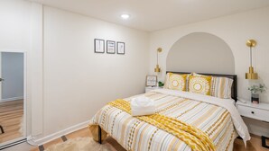 Ein Schlafzimmer mit einem Bett, Nachttischen und einer Wandlampe.