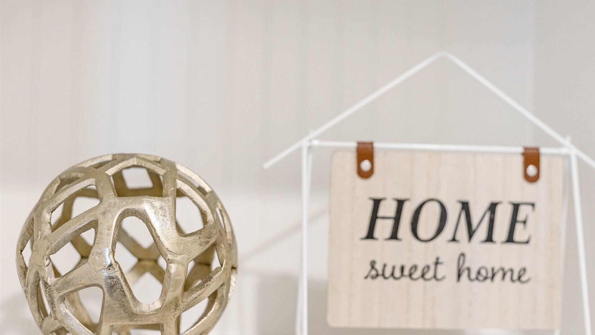 A decorative sphere and a wooden sign with 'HOME sweet home' text.