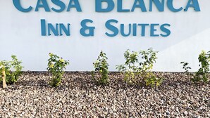 A sign for "Casa Blanca Inn & Suites" with a white background and blue lettering. - Casa Blanca Inn and Suites (Chandler)