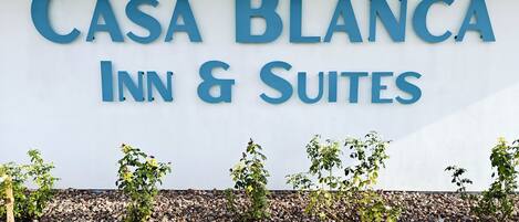 A sign for "Casa Blanca Inn & Suites" with a white background and blue lettering.