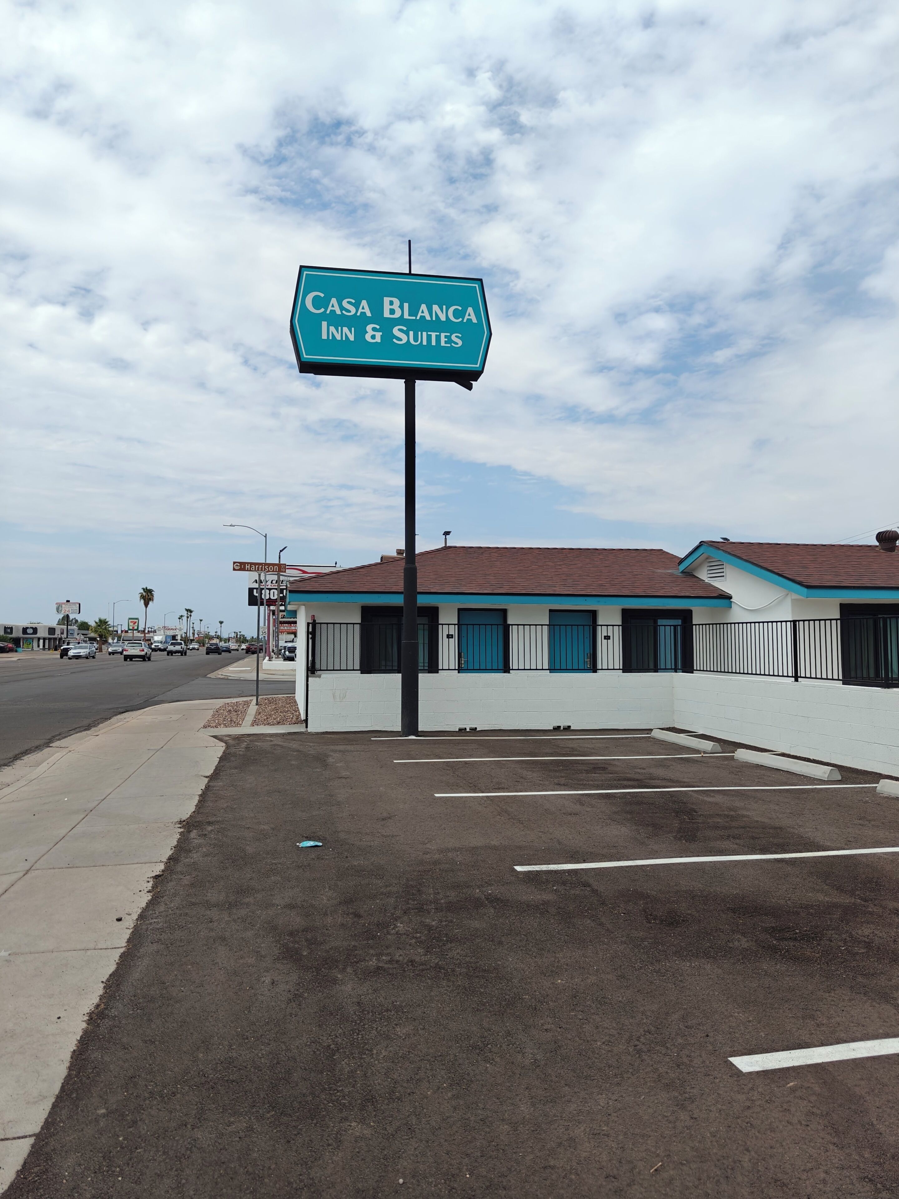 A sign for Casa Blanca Inn & Suites with a parking lot in front.