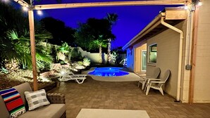 An outdoor patio area with a pool, lounge chairs, and a table. - Sun House - your own private getaway (Phoenix)