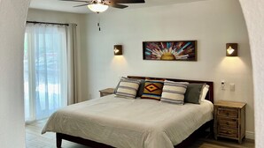 A bedroom with a bed, a ceiling fan, a nightstand, a lamp, and a painting on the wall. - Sun House - your own private getaway (Phoenix)