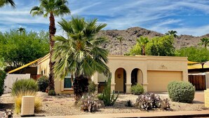 A desert-style building with arched doorways, a palm tree, and cacti in the foreground. - Sun House - your own private getaway (Phoenix)