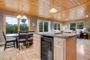 Una cocina amplia con armarios de madera, una isla central y ventanas grandes.