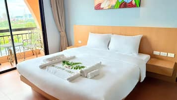 Una habitación de hotel con una cama grande, un balcón con vistas y un cuadro en la pared.