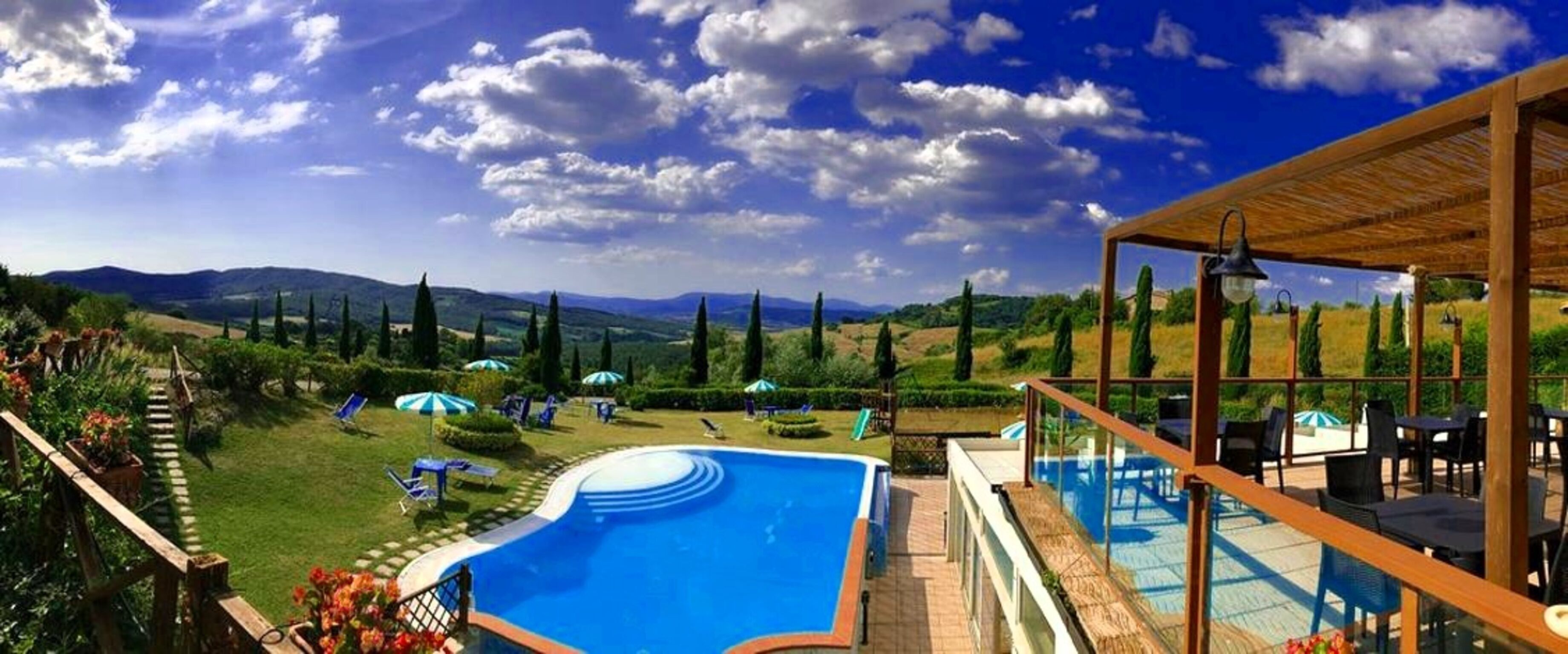 Ein Poolbereich mit Blick auf die Landschaft, einschließlich Hügeln und Bäumen.
