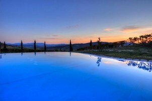 Una piscina techada, una piscina al aire libre de temporada, sombrillas