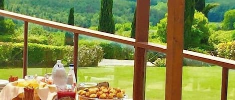Una mesa de buffet con diversos alimentos, con un paisaje montañoso de fondo.