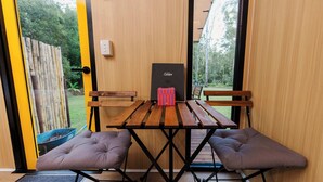 Una mesa de madera con dos sillas acolchadas, una caja negra y un banco de madera.